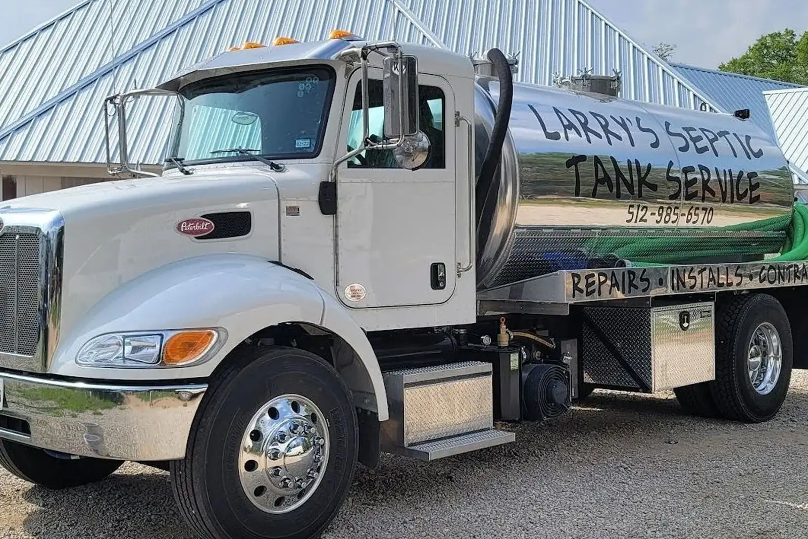 Larry’s Septic Tank Service vacuum truck: a white Peterbilt with a polished stainless tank hand-lettered “Larry’s Septic Tank Service, 512-985-6570”